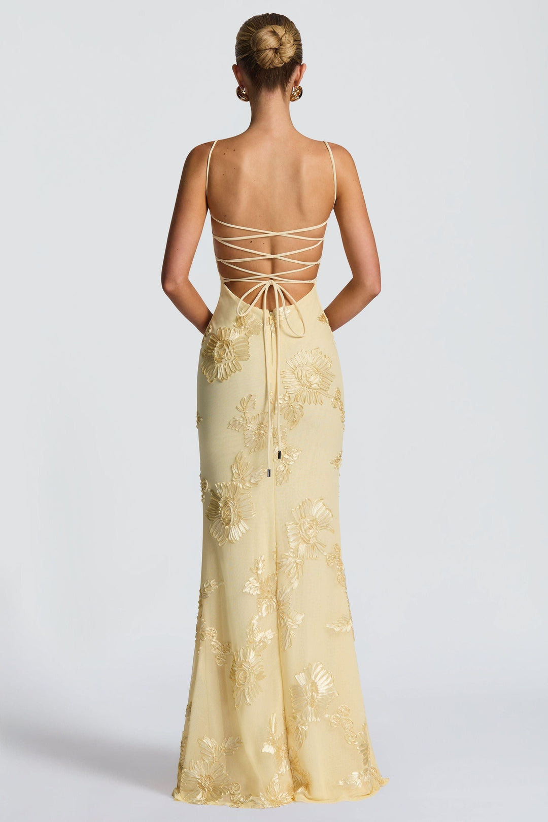 Back view of cream dress with crisscross lace-up straps and gold floral embroidery