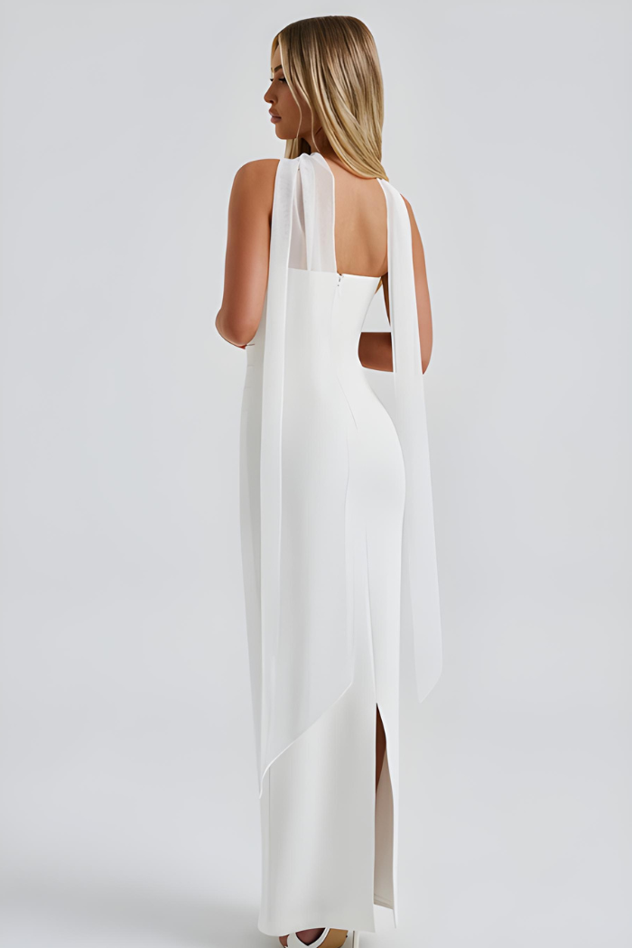 Back view of white strapless maxi dress with flowing sheer overlay and slit
