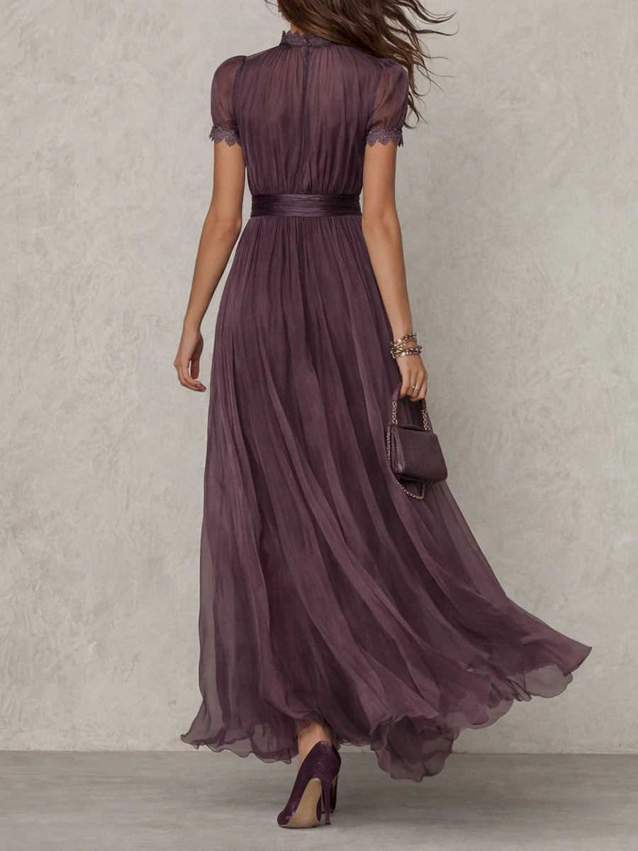 Back view of purple maxi dress with sheer short sleeves, fitted waist, and floor-length chiffon