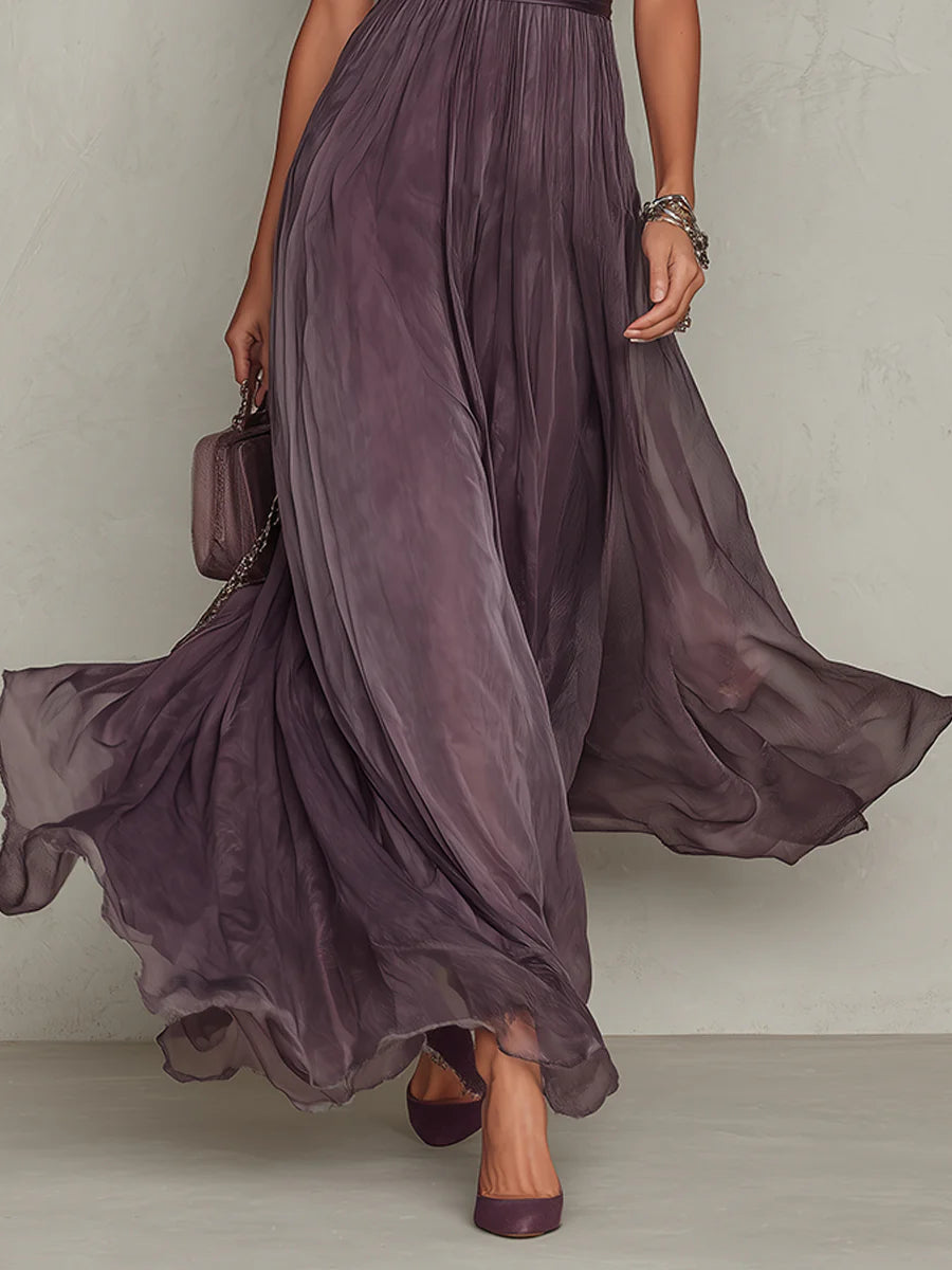 Close view of purple wedding guest dress showing keyhole front, puff sleeves, and airy maxi hem