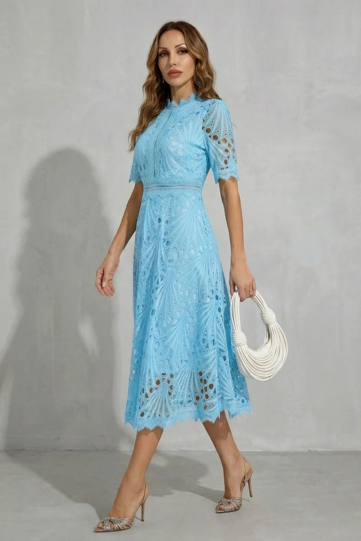Side view of light blue lace midi dress with high neck, short sleeves, and flowing skirt