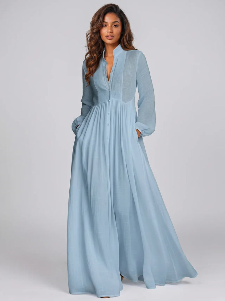 Woman wearing a light blue dress against a plain background