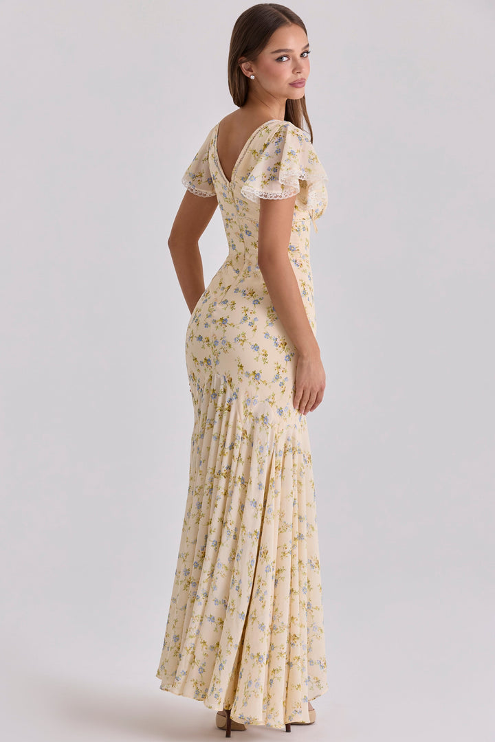 Side view of beige floral maxi dress showing flutter sleeves, deep V neck, and flowing skirt