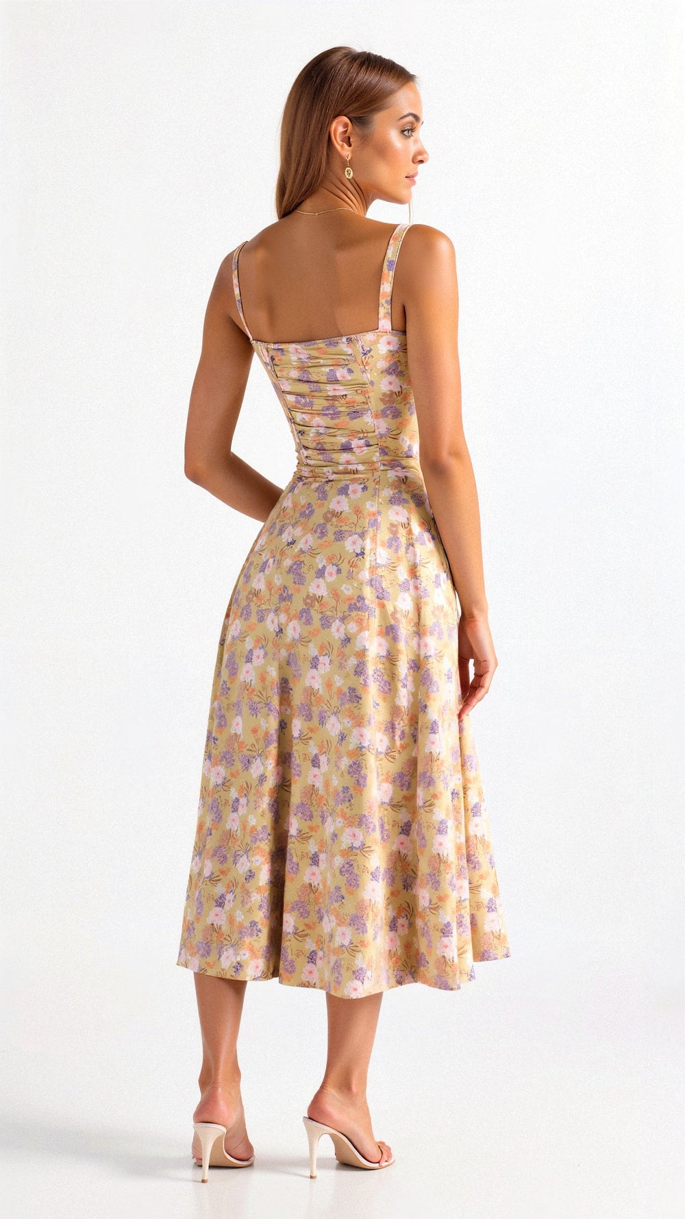 Back view of yellow floral midi dress with ruched elastic back, pink and purple flower pattern, and thin straps.