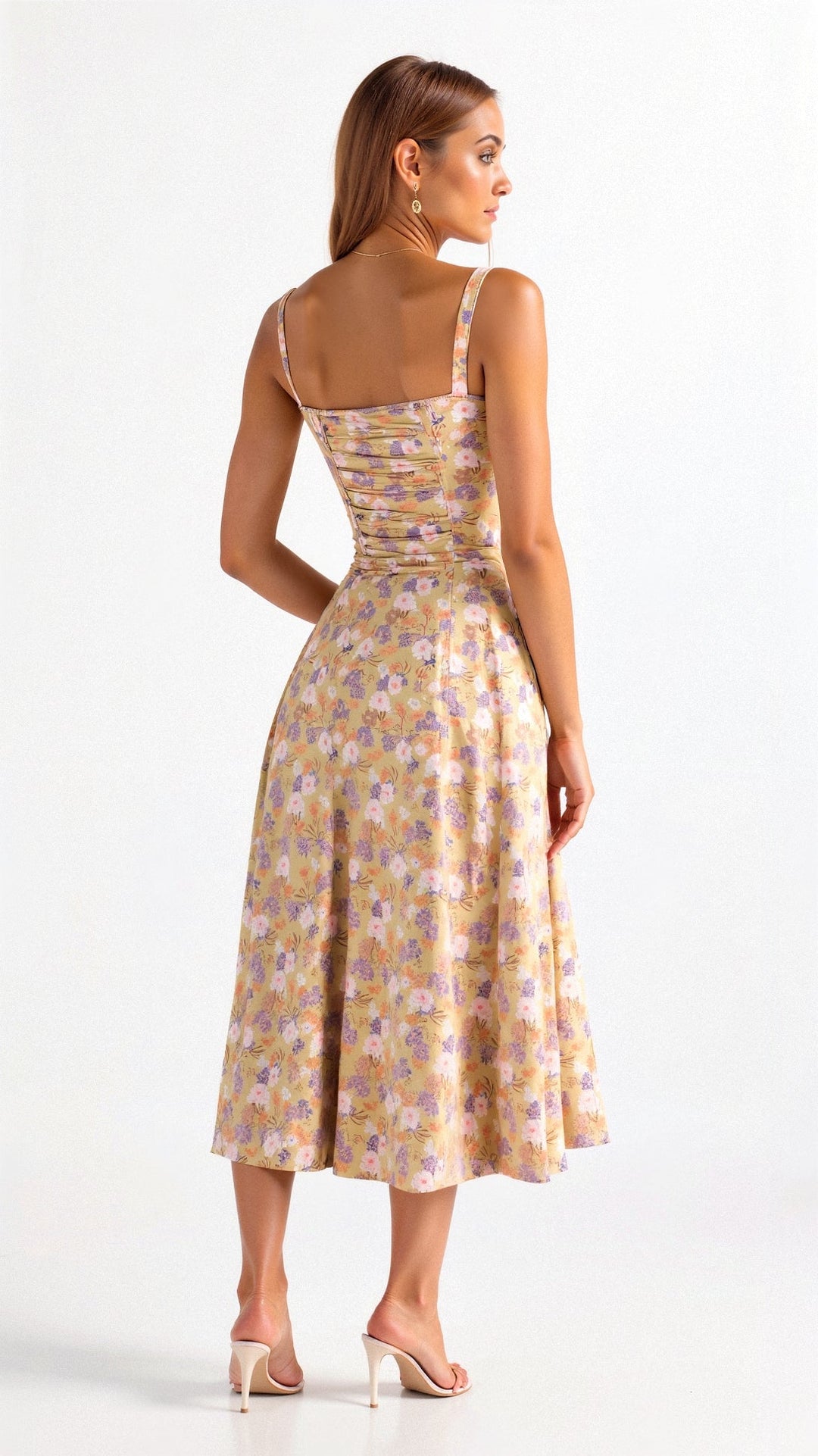 Back view of yellow floral midi dress with ruched elastic back, pink and purple flower pattern, and thin straps.
