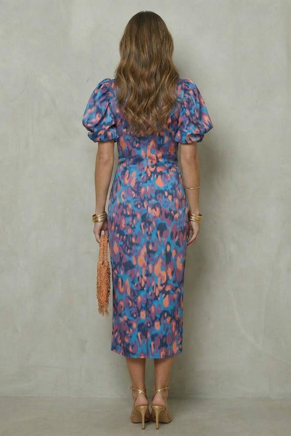 Back view of abstract print midi dress with puff sleeves and fitted silhouette
