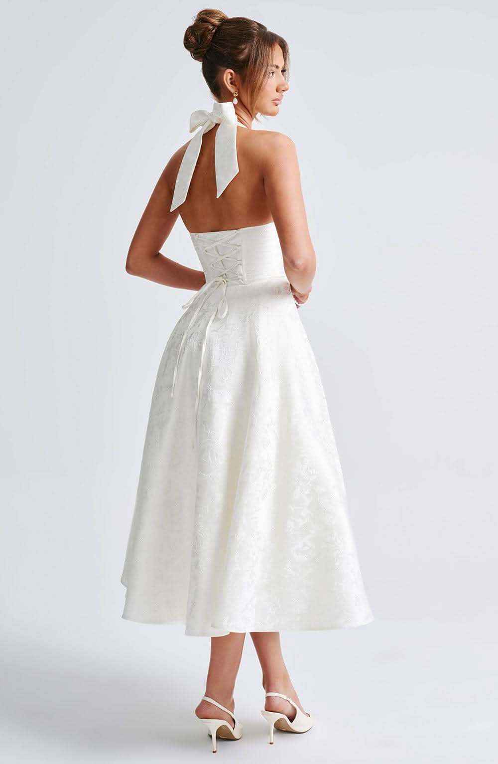 Back view of white halter dress showing lace-up corset detail