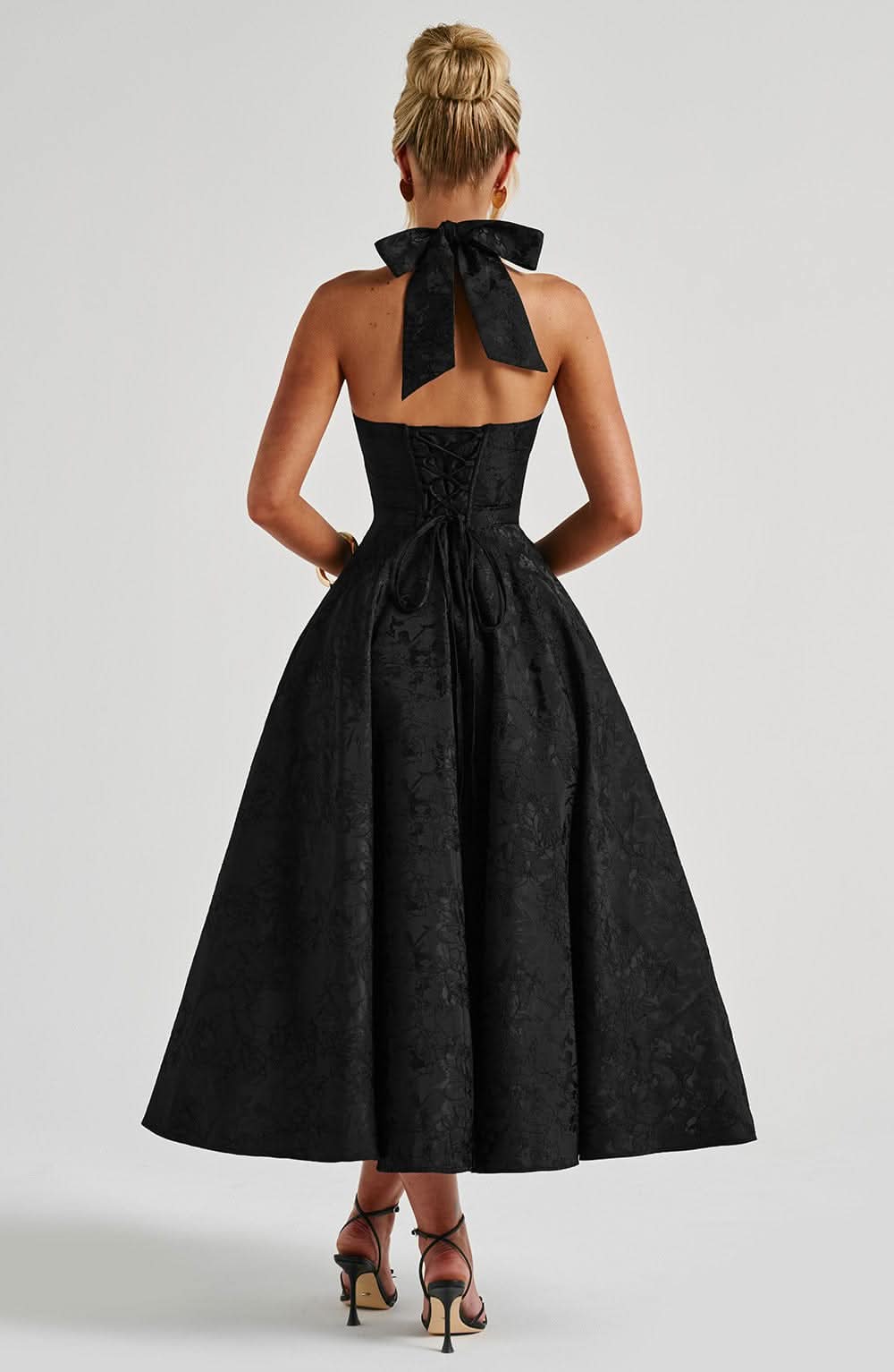 Back view of black halter dress with bow tie detail