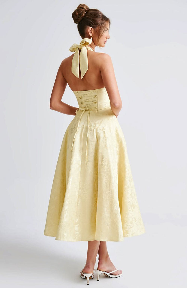Back view of pale yellow halter dress with lace-up corset detail