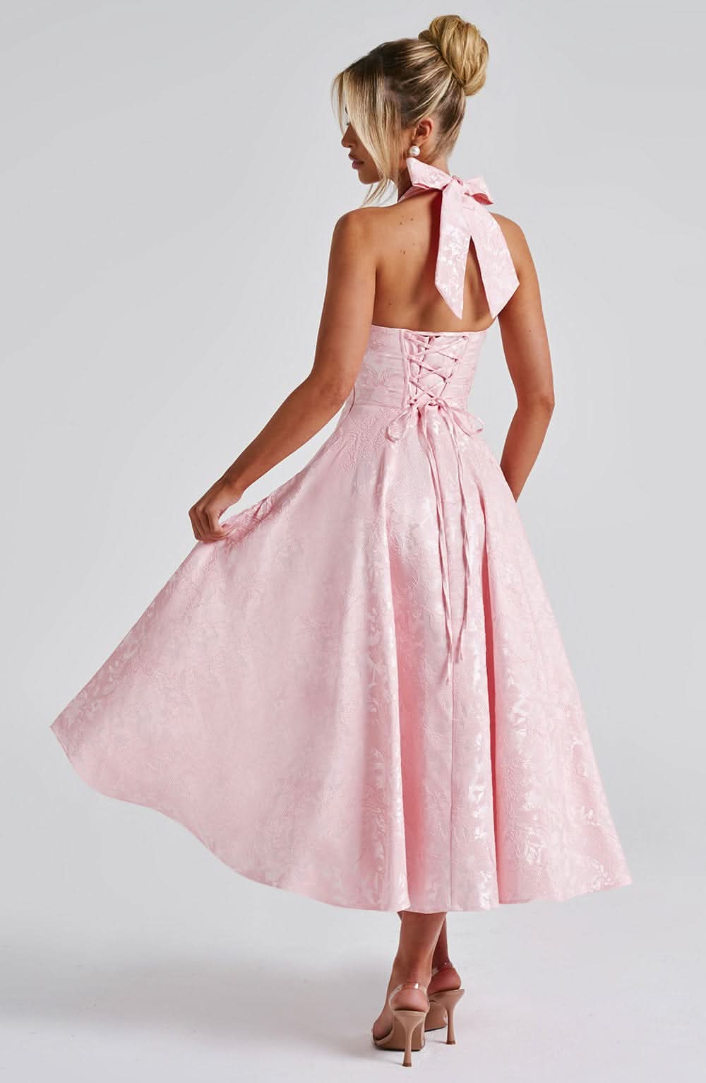Back view of blush pink halter dress with tied bow closure