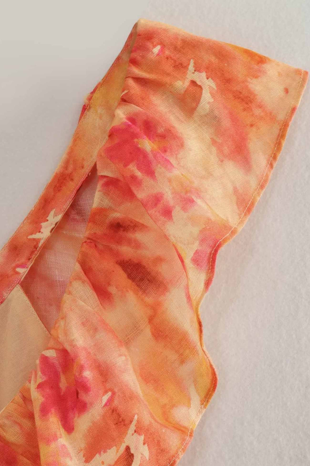 Close-up of orange floral maxi dress shoulder strap and sheer fabric texture detail