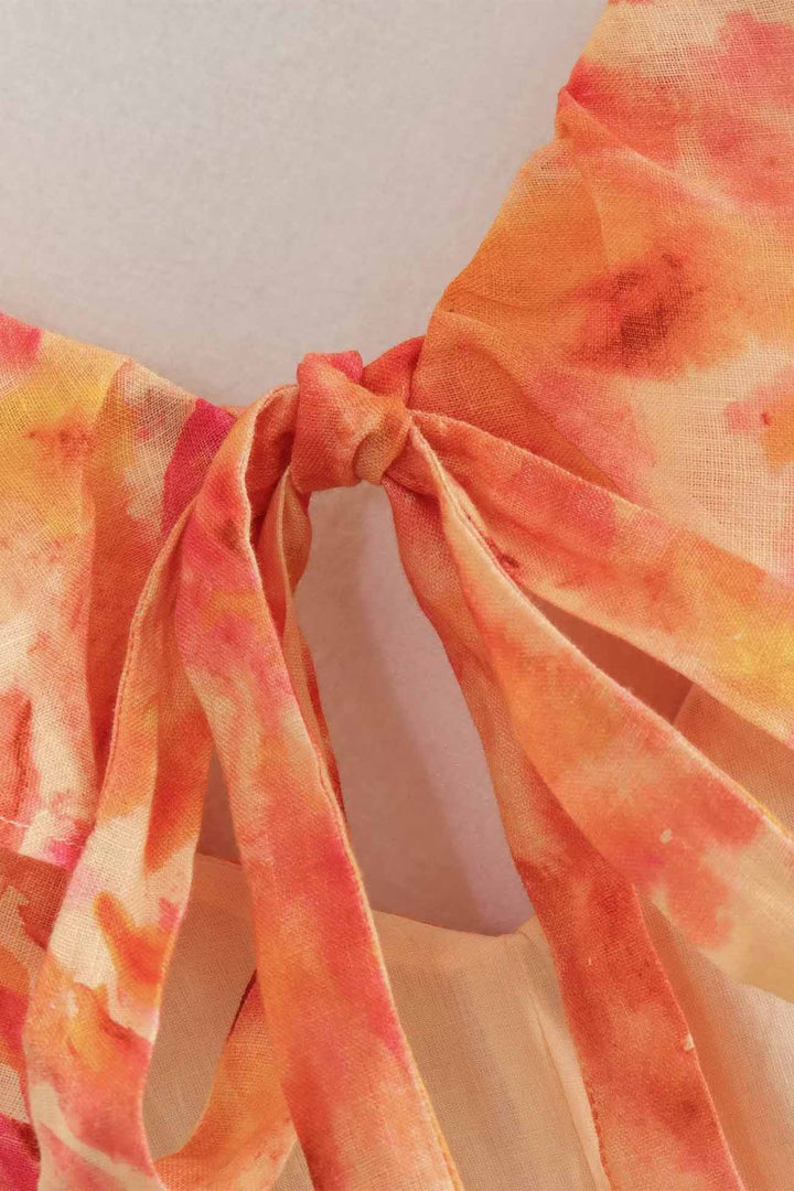 Close-up of floral V neck maxi dress tie detail in orange and pink chiffon
