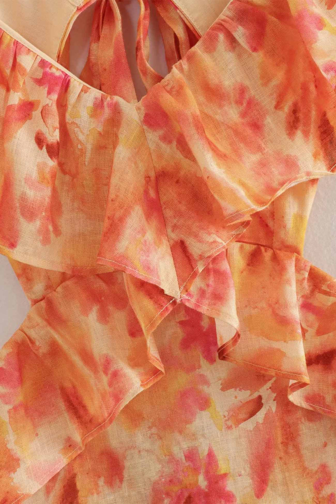 Close-up of orange floral V neck maxi dress ruffle neckline and layered bodice detail